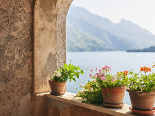 Naklejka premium Rustic Mediterranean window with potted flowers overlooking serene lake and mountains