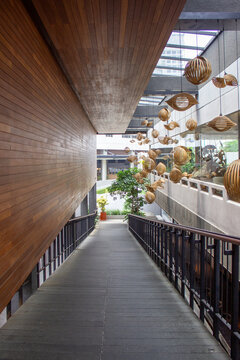 Jakarta, Indonesia - March 29, 2026: Walkway corridor with wooden walls and artistic rattan decorative lamps at the Kopitagram Centang Biru Ampera cafe area.