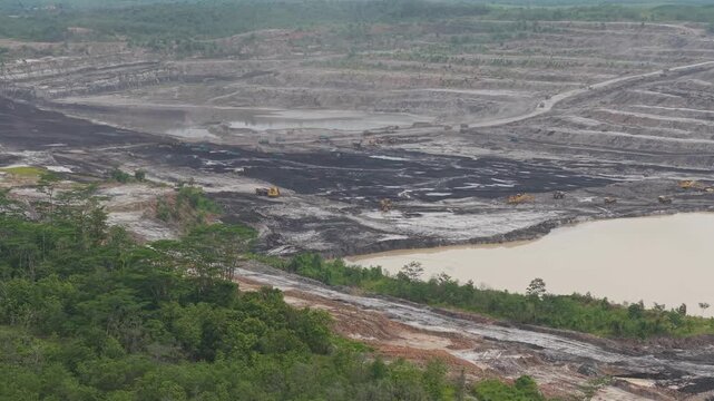 Aerial view of vast coal mines and dump truck activity loading and transporting coal