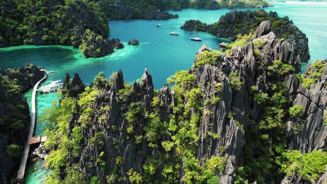 Aerial view of tropical karst mountains and turquoise lagoon with boats in Coron Palawan Philippines