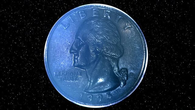 On a black background, quarter dollar coin is glitters in the rays of light. Black background with sparkling particles. Macro. Closeup