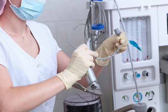 Laryngoscope for tracheal intubation and breathing tube in hands of an anesthesiologist. Performing resuscitation, artificial ventilation, and general anesthesia. Concept of healthcare.