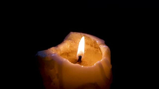 Flame flickers then dwindles completely extinguishing in darkness