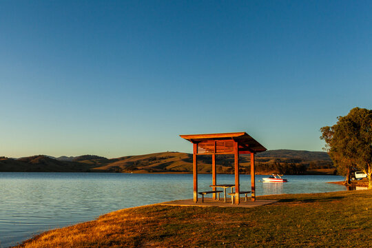 picnic shelter and table in golden sunset light beside lake in the Hunter Valley