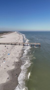 Tourists and locals enjoying the Atlantic Ocean at Saint Augustine beach pier near Anastasia State Park in St Augustine, Florida.