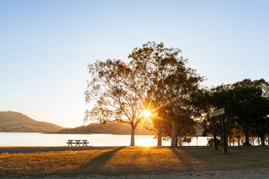 Picnic table at campground in Australia with lake waters and hills in the distance