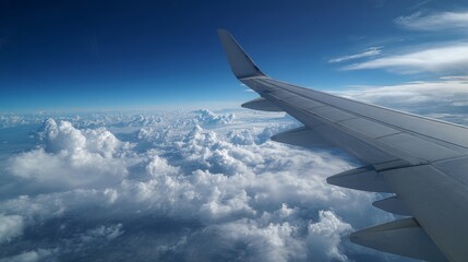 Fototapeta premium Airplane Wing Above Clouds with Expansive Sky and Travel Concept for Inspirational Imagery
