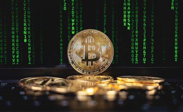 Une pi&egrave;ce de Bitcoin dor&eacute;e, pos&eacute; sur un tas au centre. En arri&egrave;re plan, un fond de lignes de code vert, symbolisant la blockchain.