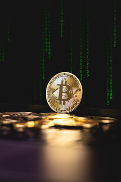 Un tas de pi&egrave;ces bitcoin avec un arri&egrave;re plan, des lignes de code, symbolisant la blockchain. Le format est vertical.