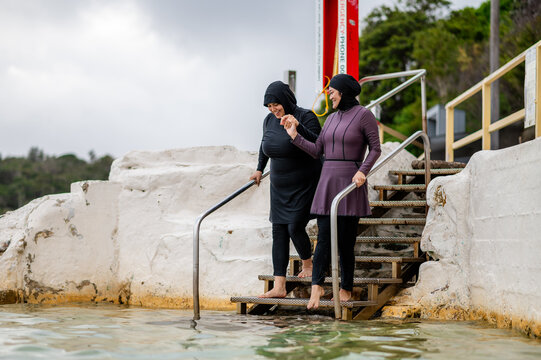 Mixed race women walking down the stairs towards the tidal pool