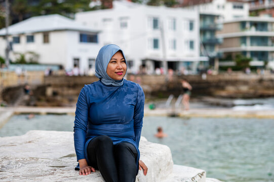 Filipina woman sitting on a rock platform near tidal pool