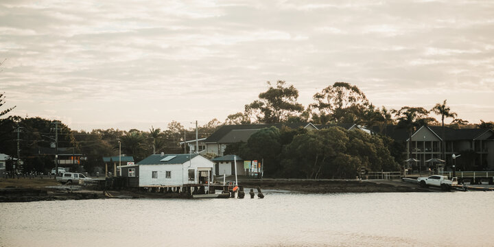Serene waterfront village with fishing sheds on stilts and cloudy sky at dusk