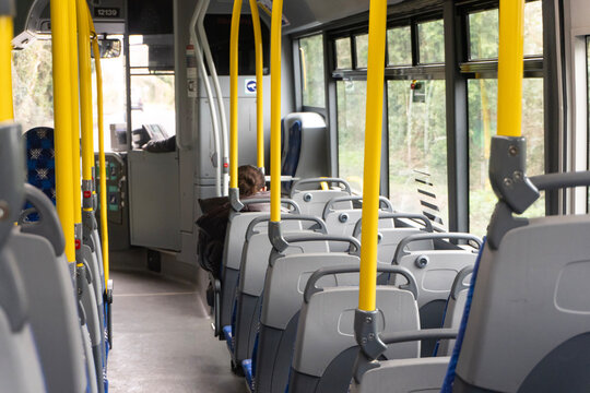 Empty public bus interior with yellow handrails and seats, modern urban transportation concept