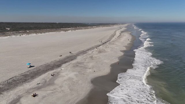 Still shot of waves lapping on a long stretch of sandy beach near Anastasia State Park in St Augustine, Florida. 