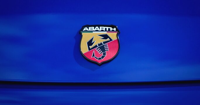 Ulm, Germany - March, 29, 2026: Close up of a Fiat Abarth car logo on blue metallic surface. Panoramic image. 