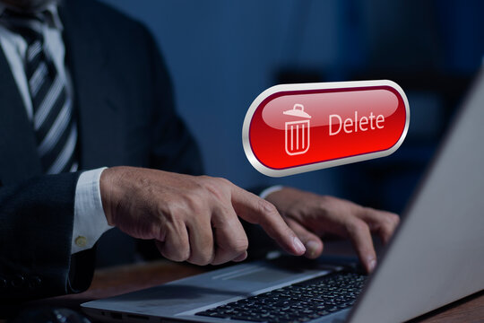 Businessman pushing the delete button on laptop. The concept of deletion or erase contacts, Deleting files from the system. Spam mail, electronic messages or personal data in computer systems.