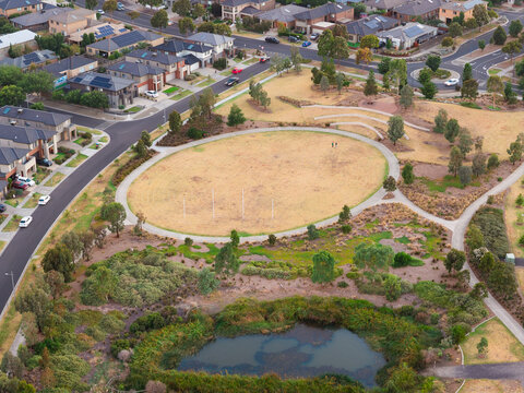 Aerial view of ponds in an urban parkland bordered by roads on housing