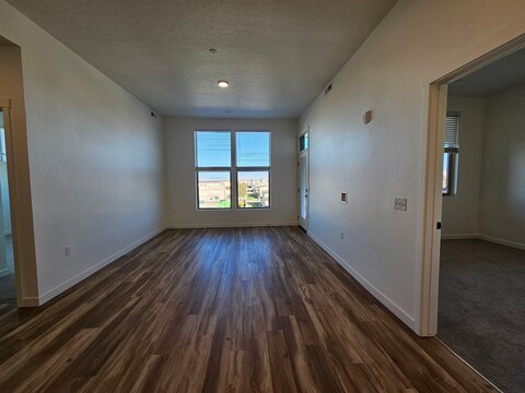 Vacant Modern Apartment Living Room with Dark Hardwood Floors and City View