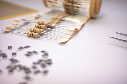 Electronic components and resistors on white background with tweezers, electronics assembly concept