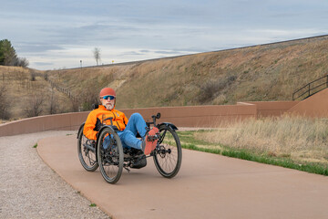 Obraz premium senior cyclist is riding a recumbent tricycle on a paved biking trail in Fort Collins, Colorado