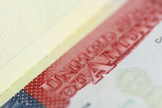 closeup shot of the united states of america heading on a visa document showing red engraved ink and intricate microprinting security features on a textured paper surface with blurred background