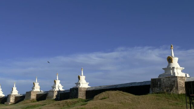 The walls of the ancient Mongolian monastery on the background of the blue cloudy sky. Stupas are sacred Buddhist structures, masonry. Monastery  Erdene Zuu,  Kharkhorin, Mongolia. Sunny summer day.