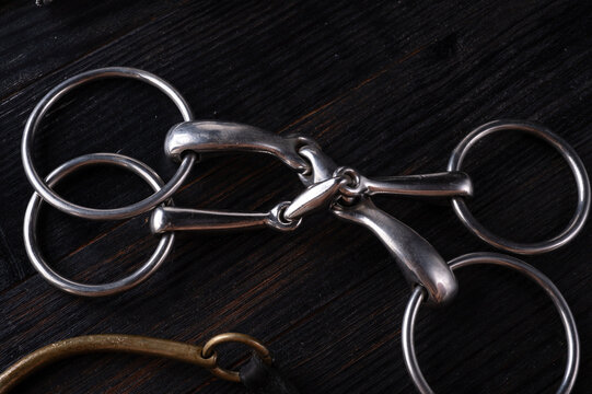 various horse bits on black wooden  table. studio shot. close up