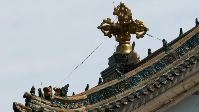 Decoration of the roof of the Mongolian temple in the form of a sacred Buddhist symbol on the background of the blue clear sky. Mongolia, Erdene Zuu monastery.