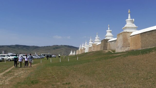 Stone wall and stupas of the ancient Buddhist monastery Erdene Zuu against the blue sky. Kharkhorin, Mongolia. . Stupas are sacred Buddhist structures. Su