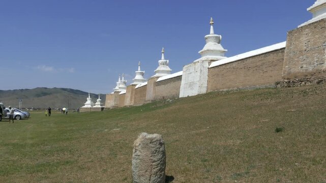 Stone wall and stupas of the ancient Buddhist monastery Erdene Zuu against the blue sky. Kharkhorin, Mongolia. . Stupas are sacred Buddhist structures. Su