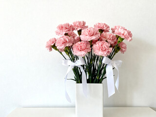 Fototapeta premium Carnation flower arrangement in minimalist natural light with copy space, celebration and mother's day concept