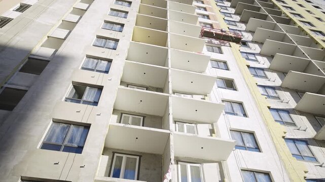 Panel facade of high rising condominium building with windows and balconies low angle shot. Constructing contemporary residence in district