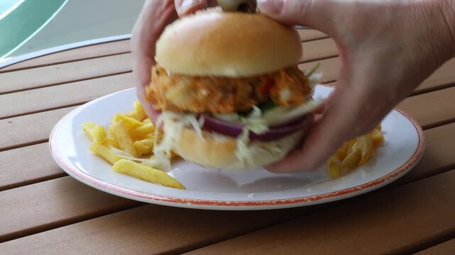 Eating a Deep Fried Fish Burger and French Fries