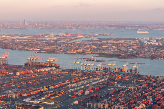 Port of Newark, Newark, New Jersey, USA - November 19, 2023 - Aerial view of Port Newark-Elizabeth Marine Terminal at dusk with shipping containers, gantry cranes and shipping channels of NY Harbor