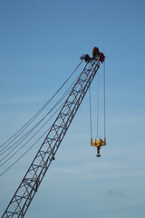Naklejka premium Low Angle View of Industrial Crane Hook Against Clear Blue Sky