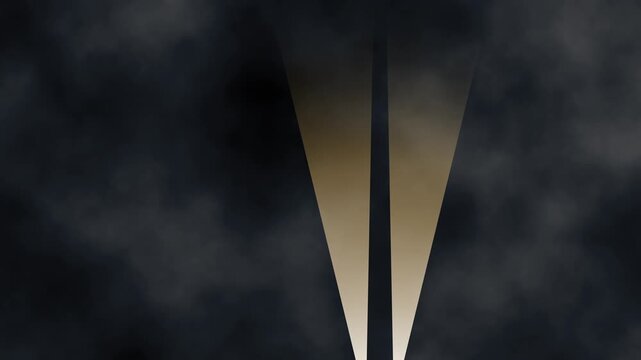 two bright searchlight spotlights with golden yellow beams of light moving in the night time sky with soft white clouds of smoke or fog reminiscent of world War II blitz air raids or movie premieres