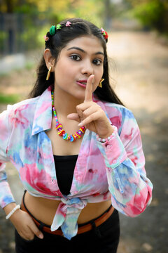 Stylish young Indian woman wearing a casual outfit with vibrant accessories, posing outdoors in natural daylight
