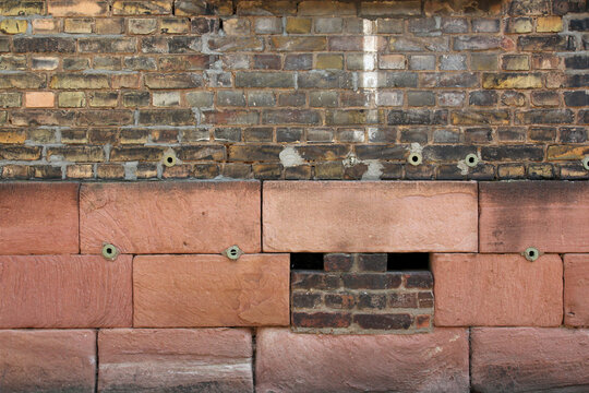 Wall with textured bricks and sandstone blocks