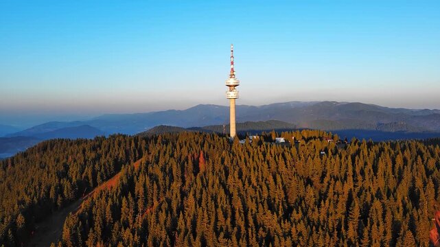 Tower Snezhana on peak of Snezhana covered with spruce forests in Rhodope mountains