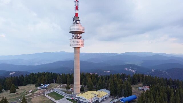 Tower Snezhana on peak of Snezhana covered with spruce forests in Rhodope mountains