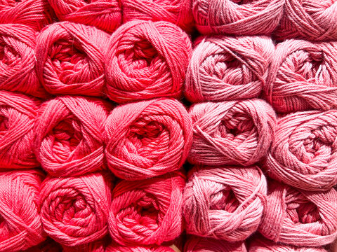 Balls of pink wool neatly arranged and on sale in a haberdashery shop