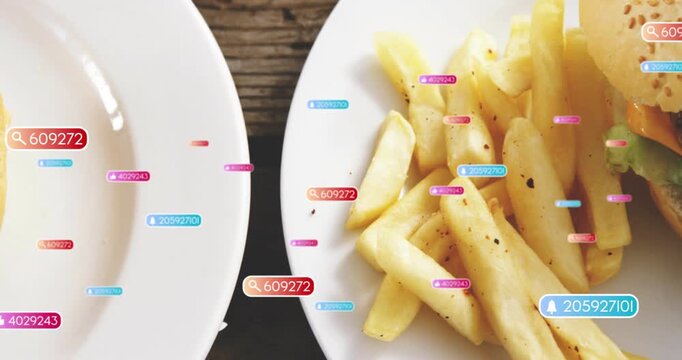 Vertical video: Popping labels drifting at wood table, frame shifting showing sesame burger, fries
