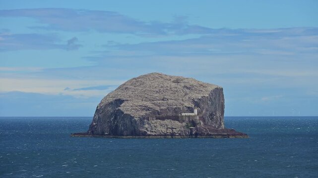 Felsige Insel Bass Rock im blauen Meer unter leicht bew&ouml;lktem Himmel, North Berwick, East Lothian, Schottland, Vereinigtes K&ouml;nigreich, Gro&szlig;britannien