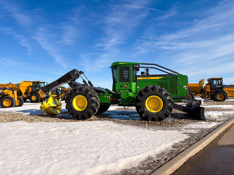 Regina, Canada - February 2026:  John Deere dealership sign with deer logo and Brandt Tractor branding, displayed outdoors against blue sky representing agriculture and construction equipment company.