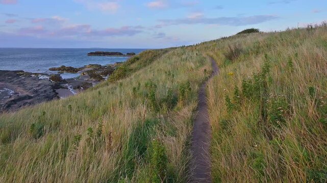 Schmaler Pfad durch grasbewachsene H&uuml;gel entlang der K&uuml;ste mit Blick auf das Meer, North Berwick, East Lothian, Schottland, Vereinigtes K&ouml;nigreich, Gro&szlig;britannien