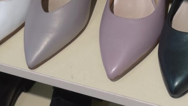 Women's pointed-toe shoes in a row on a shoe store shelf, close-up