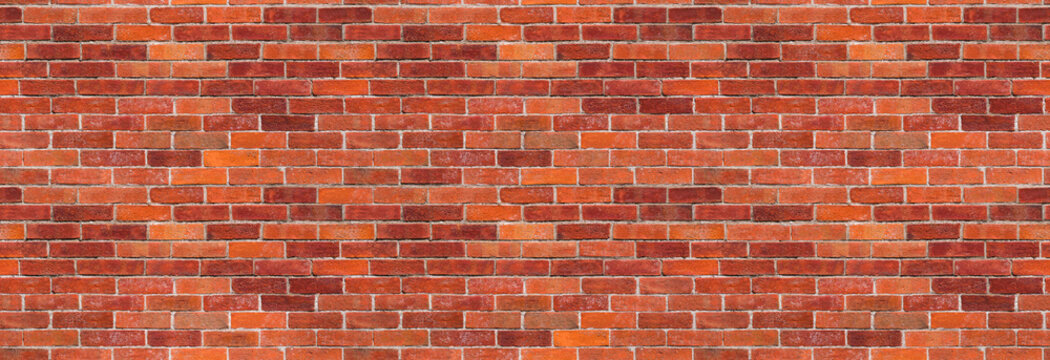 Red brick wall background &ndash; brickwall building backdrop with exposed brown stone blocks. The file is a seamless texture, allowing the photo to be tiled.