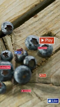Vertical video: Blueberries on wood, camera panning, revealing play and like badges for marketing