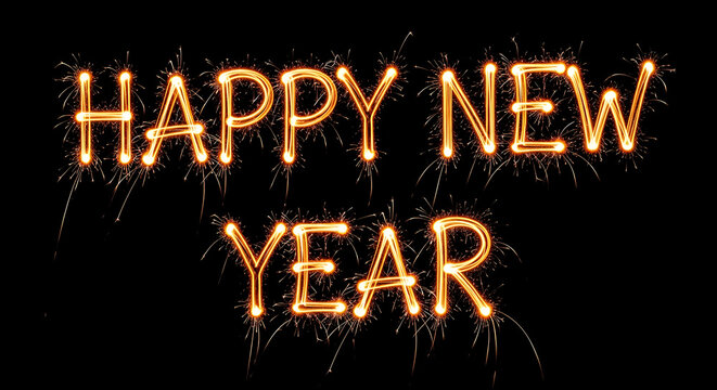 Happy new year text written with sparklers in the dark, celebrating the new year with fireworks and festive light
