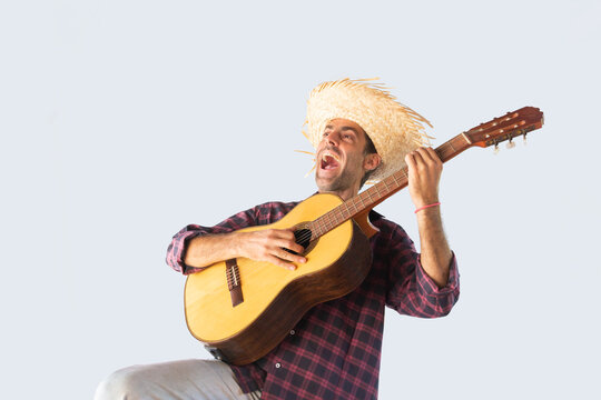 Man dressed for the June festivities singing with a guitar. Isolated
